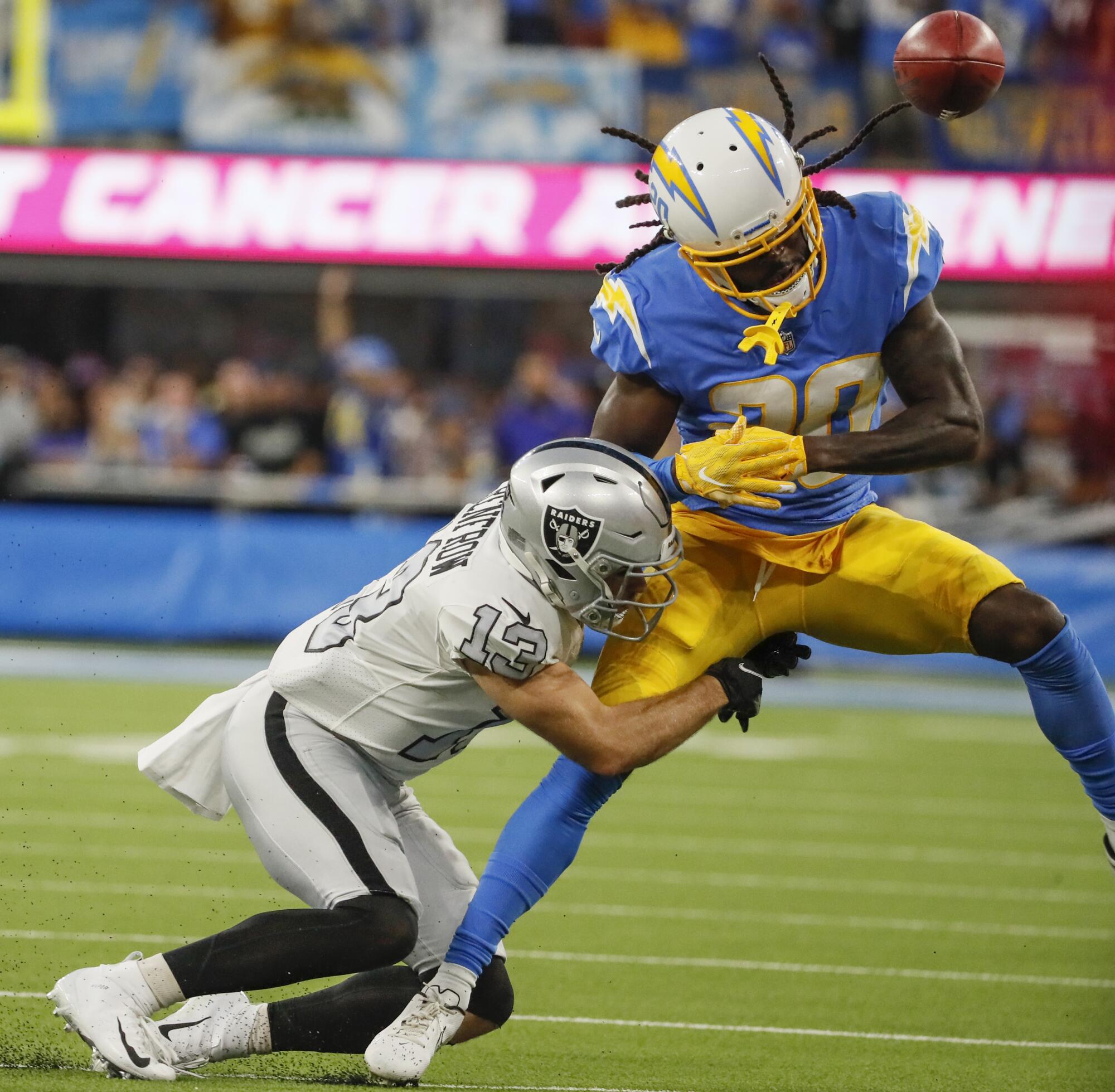 Chargers defensive back Tevaughn Campbell loses control of the ball as Raiders wide receiver Hunter Renfrow knocks it loose.