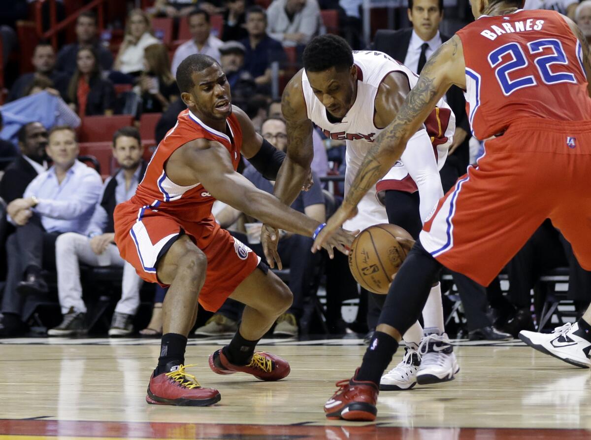 Miami guard Mario Chalmers tries to drive between Chris Paul, left, and Matt Barnes, right, during the first half of the Clippers' 110-93 win over the Heat.
