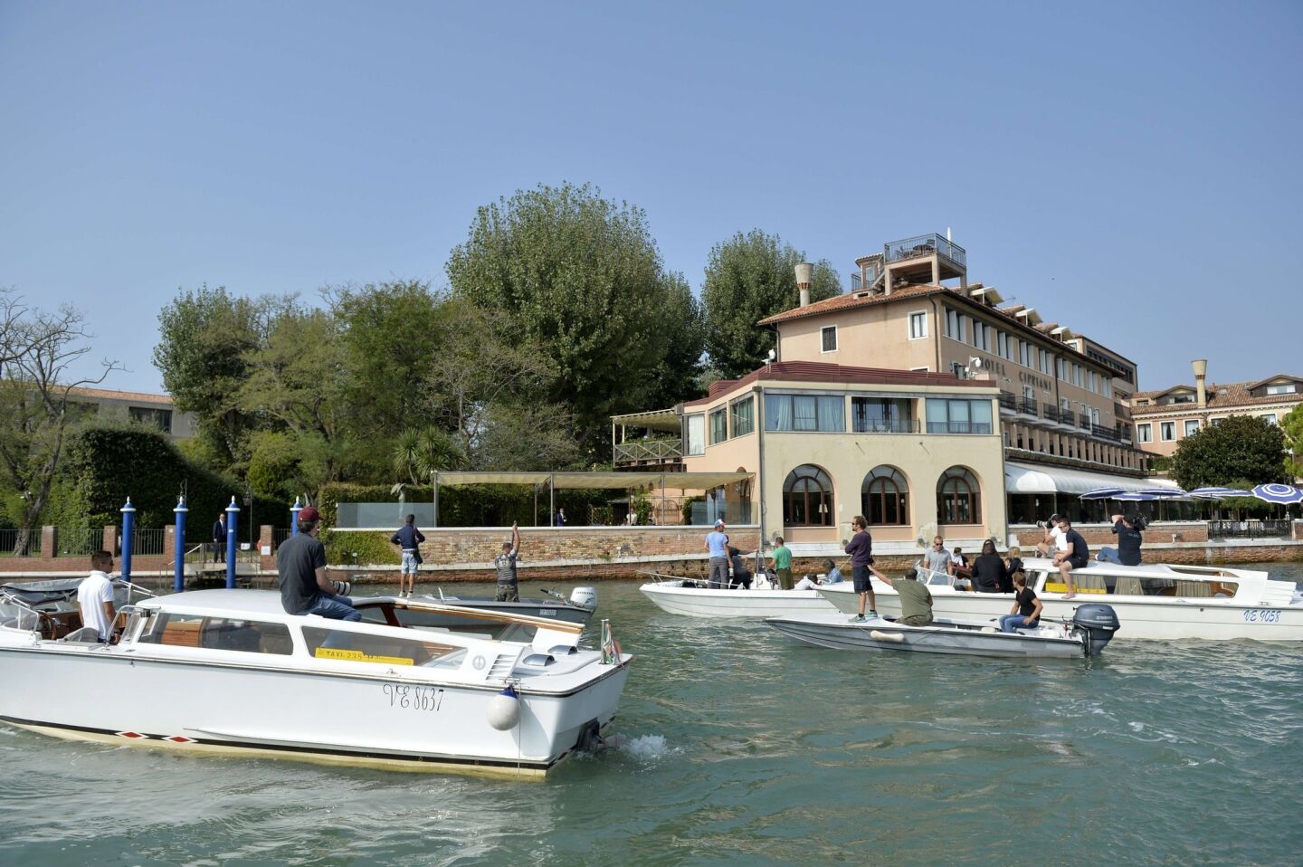 Photographers stand on boats Saturday in the canal in front of the Cipriani Hotel, where George Clooney and a number of wedding guests were staying.