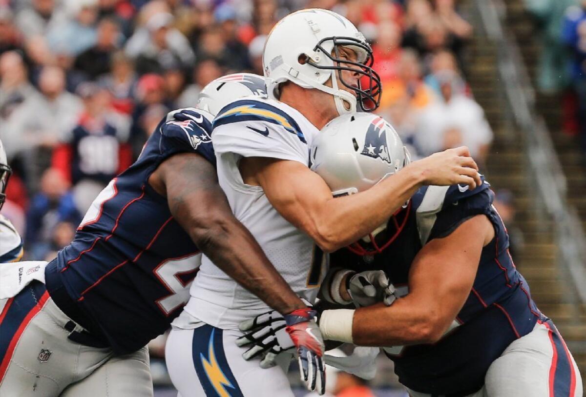 Chargers quarterback Philip Rivers is hit by David Harris and Lawrence Guy during the fourth quarter of a game in Foxborough, Mass, on Sunday.