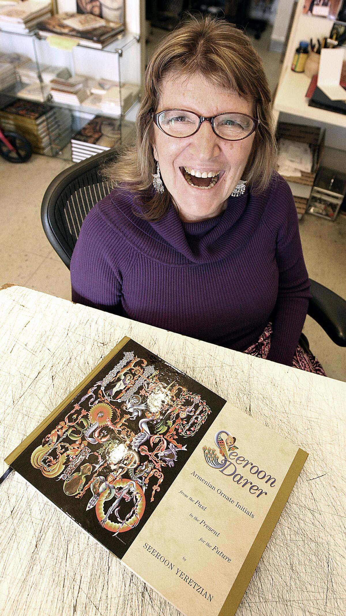 Seeroon Yeretzian, owner of Rosslin Gallery in Glendale, and her new book featuring ornate Armenian letters.