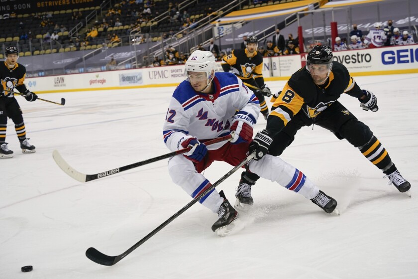 New York Rangers' Julien Gauthier (12) and Pittsburgh Penguins' Brian Dumoulin (8) chase the puck during the second period of an NHL hockey game, Sunday, March 7, 2021, in Pittsburgh. (AP Photo/Keith Srakocic)