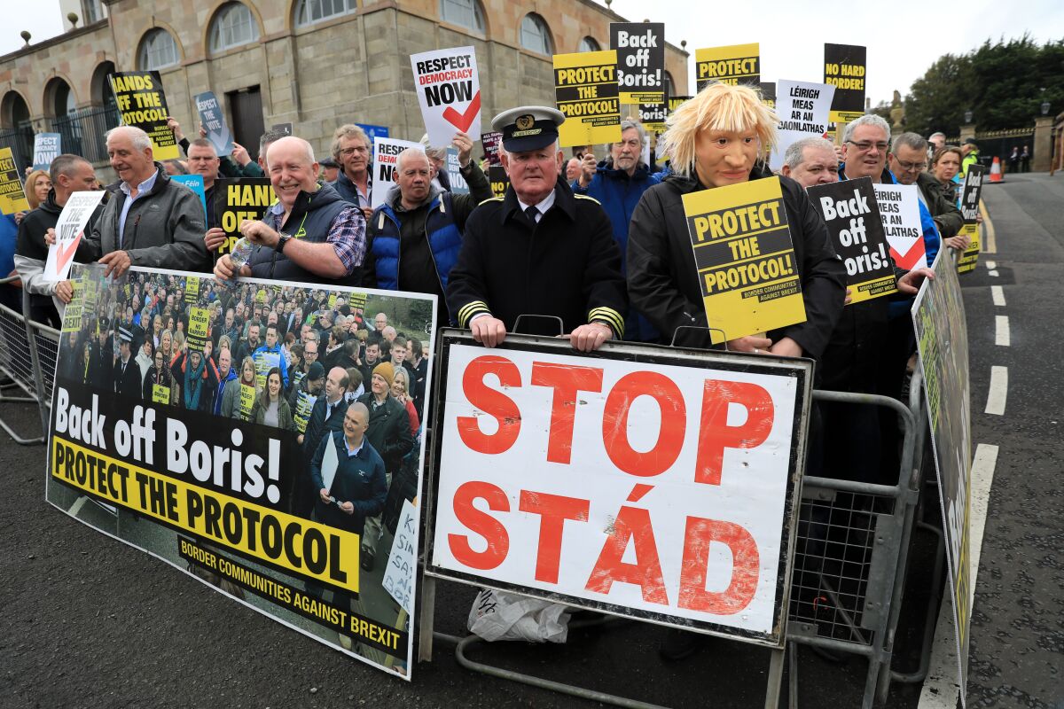 FILE - Demonstrators protest outside Hillsborough Castle, ahead of a visit by British Prime Minister Boris Johnson, in Hillsborough, Northern Ireland, Monday, May, 16, 2022. Britain’s government is expected to introduce legislation that would unilaterally change post-Brexit trade rules for Northern Ireland amid opposition from lawmakers who believe the move violates international law. The legislation, expected Monday, June 13, 2022, would let the government bypass the so-called Northern Ireland Protocol, which requires the inspection of some goods shipped there from other parts of the United Kingdom. (AP Photo/Peter Morrison, File)