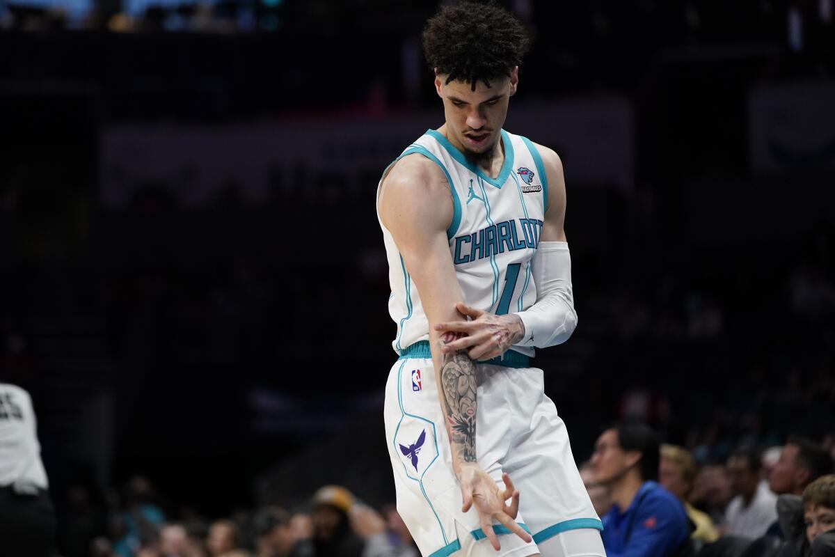 Charlotte Hornets guard LaMelo Ball reacts after scoring a 3-point shot in the first half of an NBA basketball preseason game against the Oklahoma City Thunder, Sunday, Oct. 15, 2023, in Charlotte, N.C. (AP Photo/Erik Verduzco)