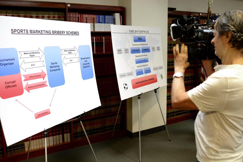 A cameraperson shoots the boards detailing the charges against FIFA officials Wednesday in New York.