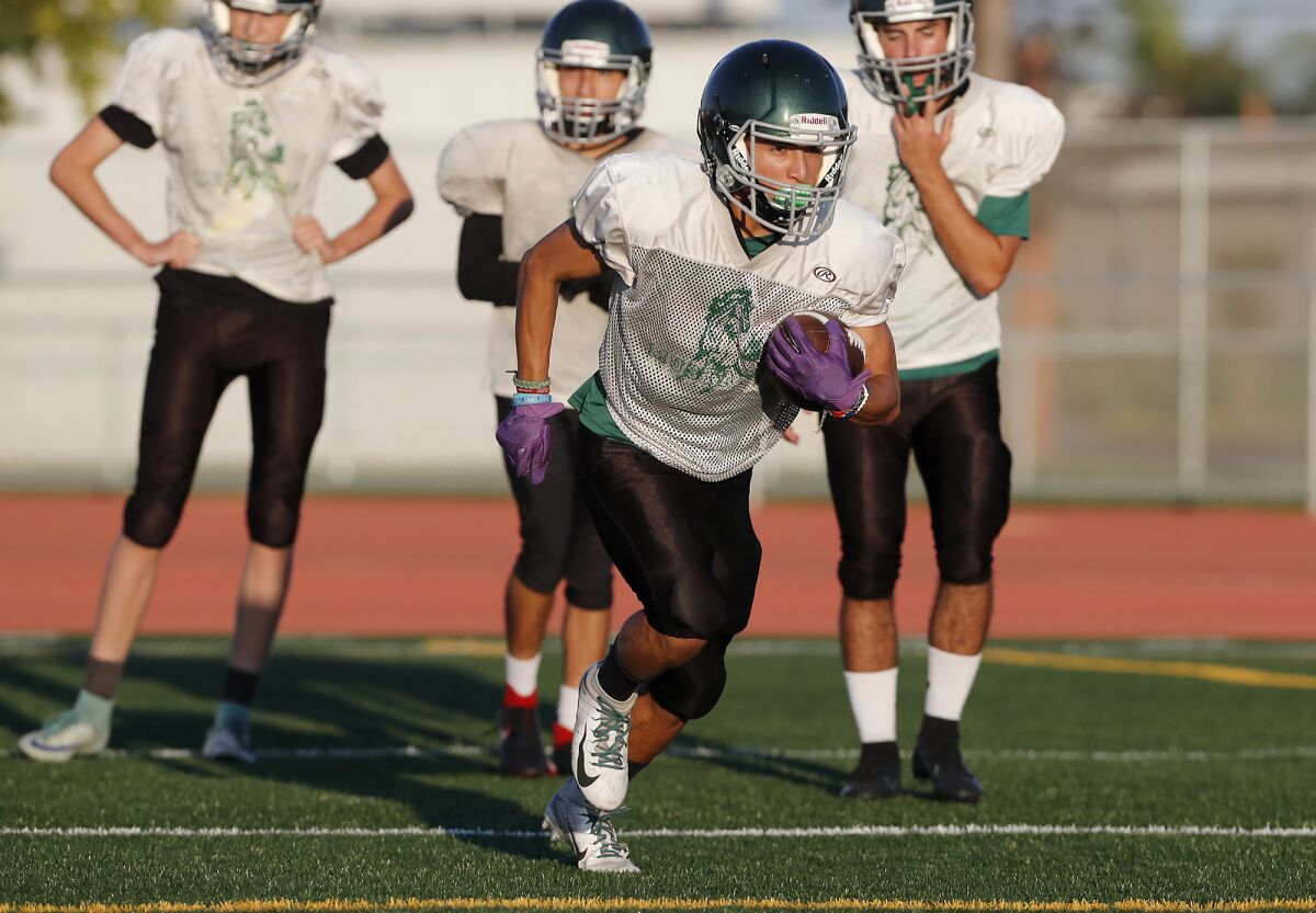 Bryan Hernandez carries the ball during Costa Mesa's practice on Monday.