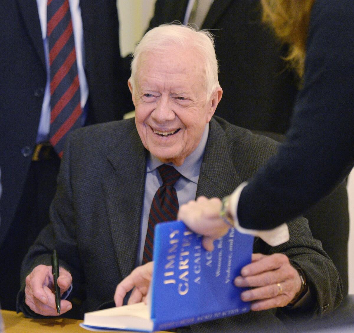 Former President Carter signs a copy of his new book, "A Call to Action: Women, Religion, Violence, and Power," at Women and Children First Bookstore in Chicago. At a stop in Portland, Ore., he signed 1,600 copies in one sitting.