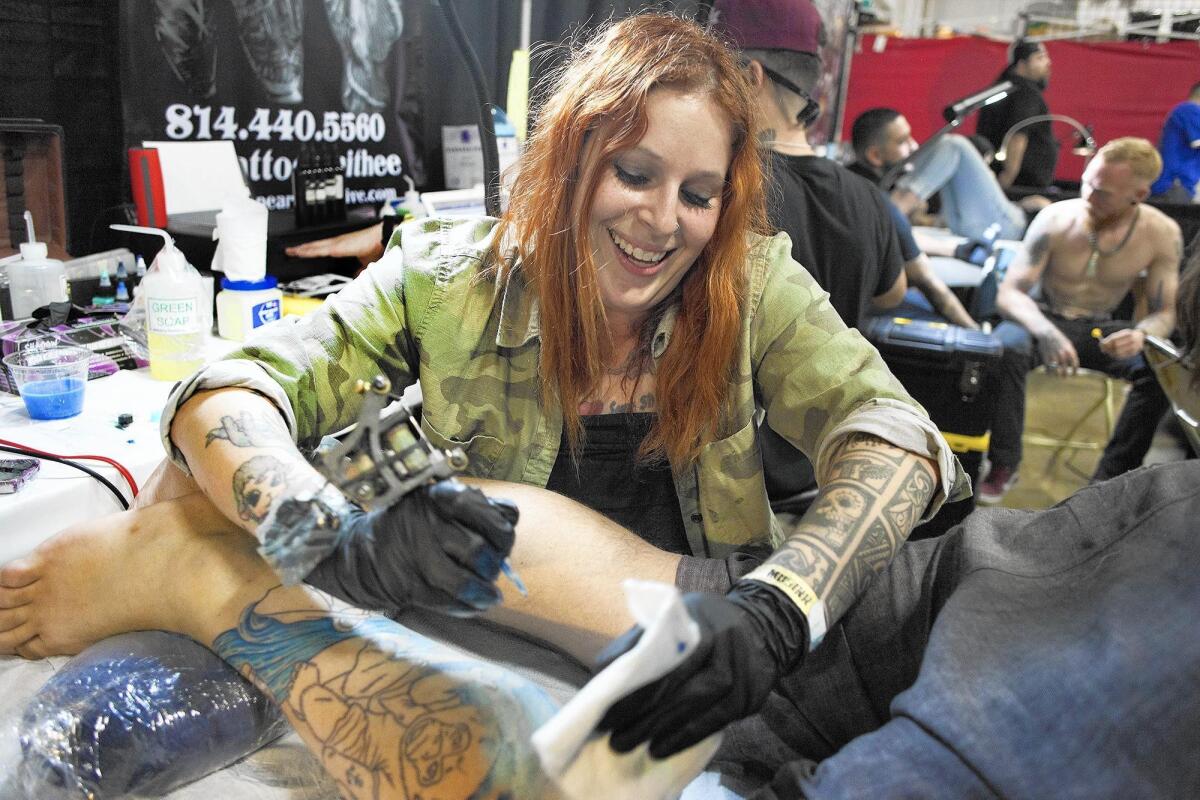 Artist Melissa Daye works on a piece for Cameron Lester of Costa Mesa during last year’s Musink Tattoo Convention and Music Festival, which returns to the OC Fair & Event Center this weekend.