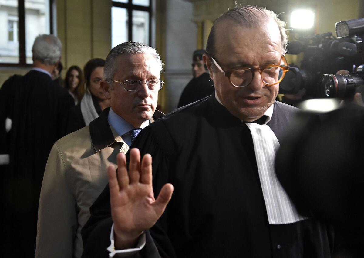 Art dealer Guy Wildenstein (in tan coat) is seen leaving a Paris courthouse last week. Several members of his influential art dealing clan have been charged with tax fraud and money-laundering.