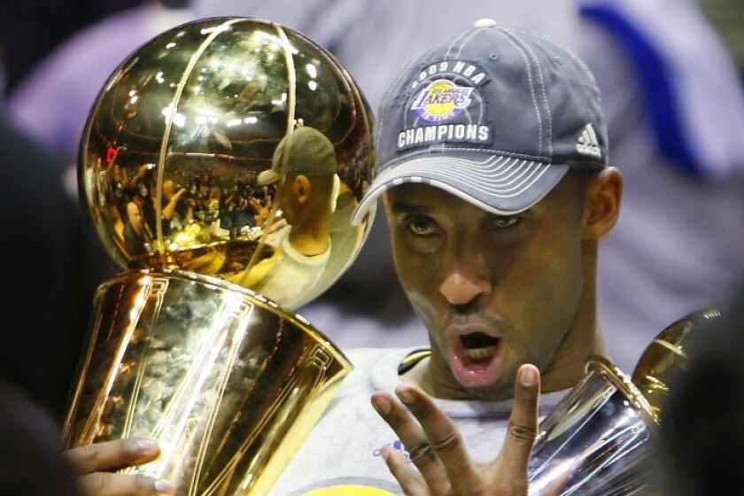 Lakers guard Kobe Bryant holds the Larry O’Brien Trophy while celebrating his fourth championship during the 2009 NBA Finals.