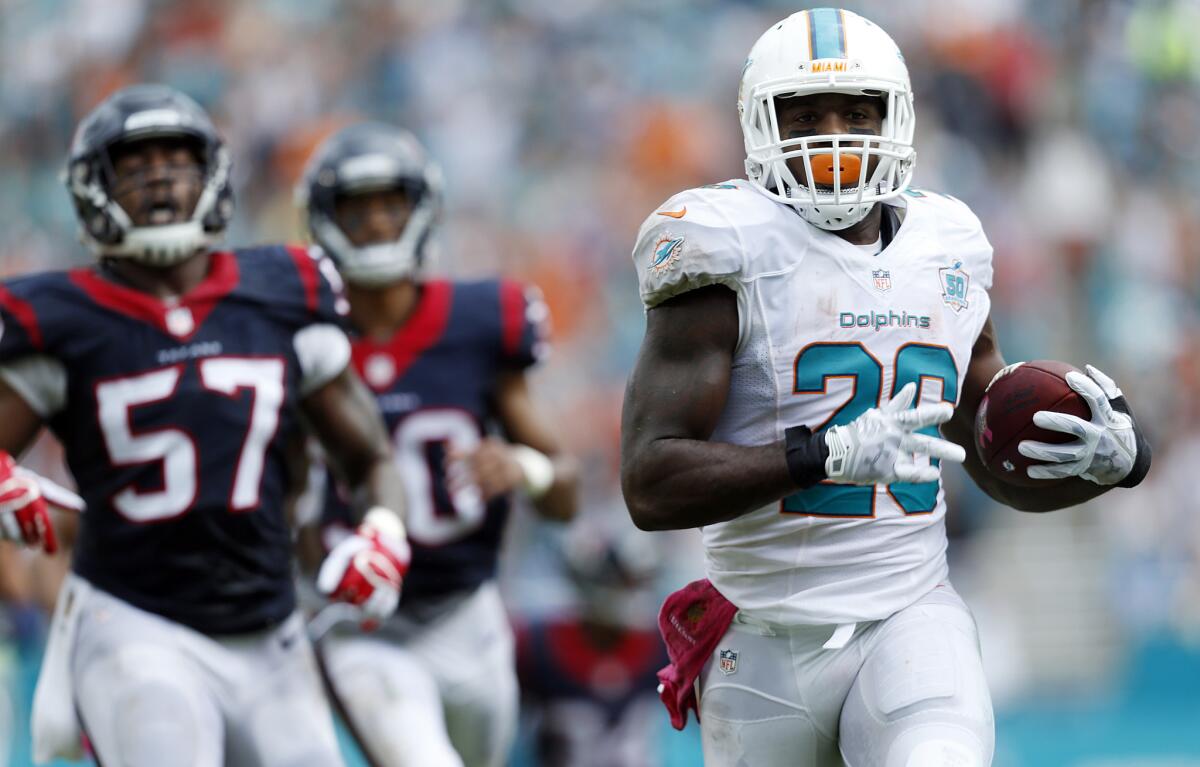 Dolphins running back Lamar Miller heads to the end zone for a touchdown against the Texans during the first half Sunday.