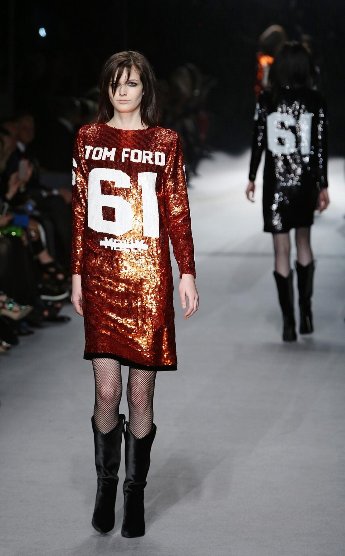 Models wear dresses with Jay-Z-inspired graphics at Tom Ford's London Fashion Week show.
