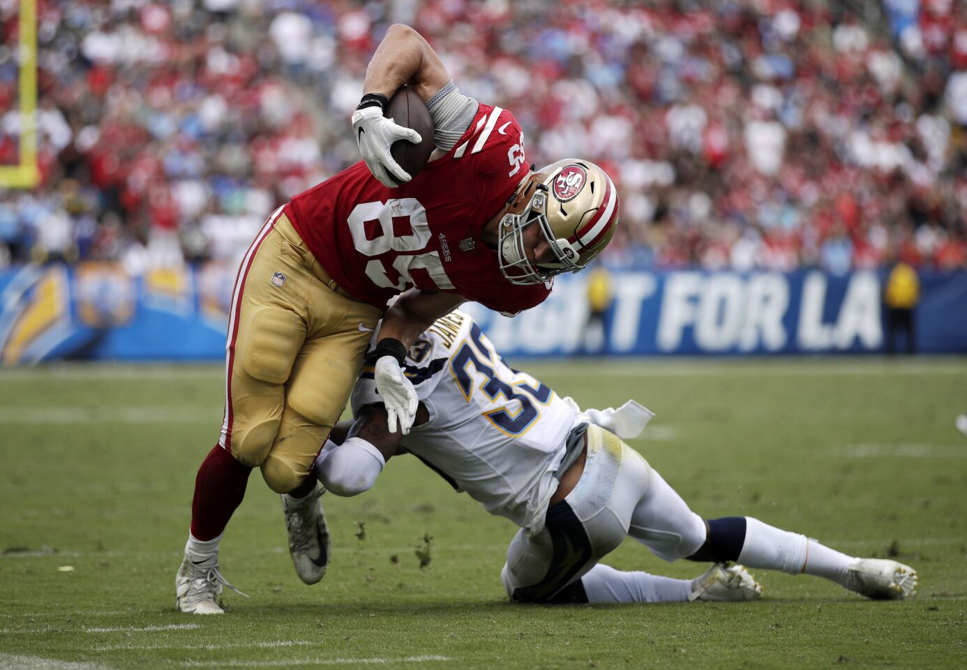 San Francisco 49ers tight end George Kittle, left, is tackled by Los Angeles Chargers defensive back Derwin James during the first half of an NFL football game, Sunday, Sept. 30, 2018, in Carson, Calif.