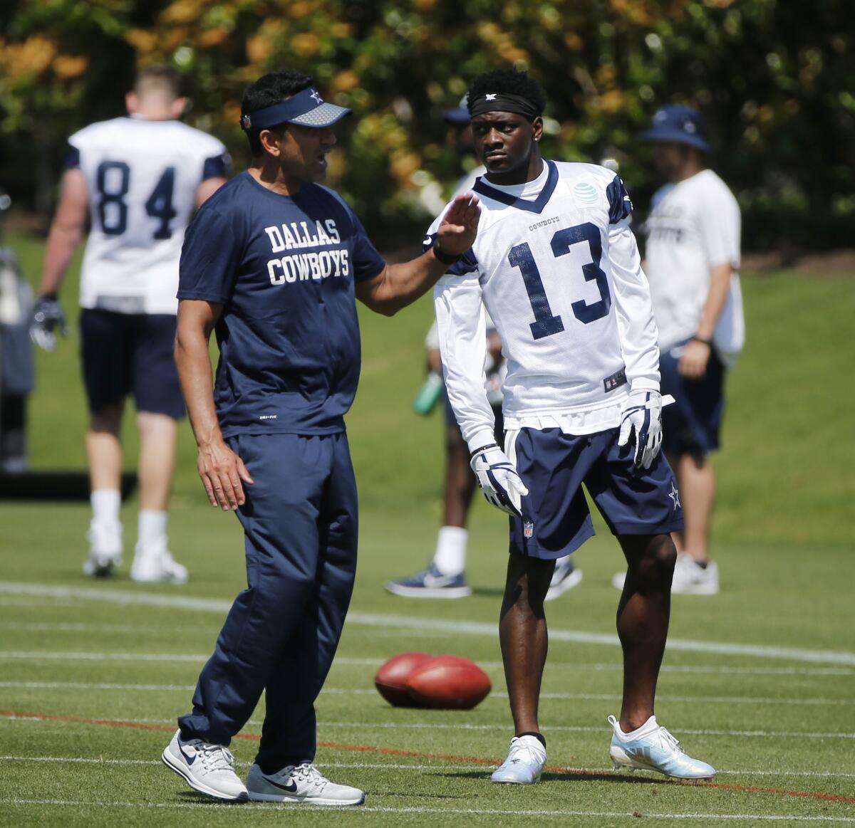 L'entraîneur des receveurs des Cowboys de Dallas, Sanjay Lal, parle au receveur Michael Gallup en 2019.