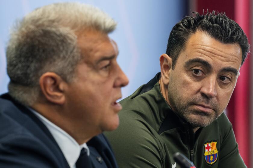 Barcelona's head coach Xavi Hernandez listens to Barcelona's president Joan Laporta during a press conference in Barcelona, Spain, Thursday, April 25, 2024. Coach Xavi Hernández will stay with Barcelona for another year after all. He has agreed with the club to finish his contract to 2025 after having decided to quit at the end of the season. (AP Photo/Emilio Morenatti)