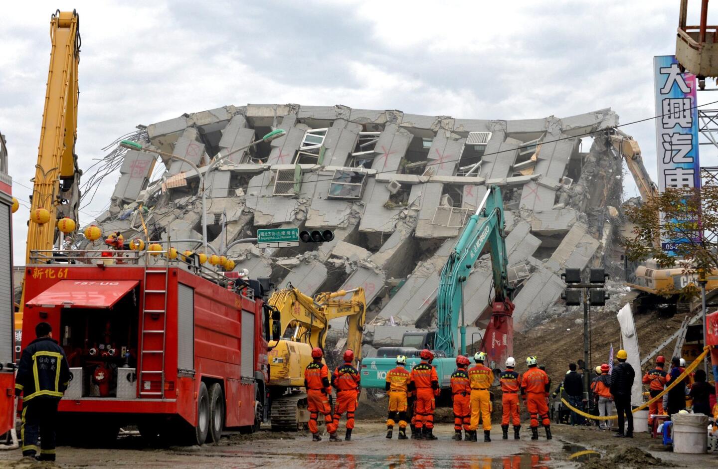 A handout photo from the Fokuangshan Monastery shows rescuers stand beside a collapsed building in Tainan on Feb. 10.