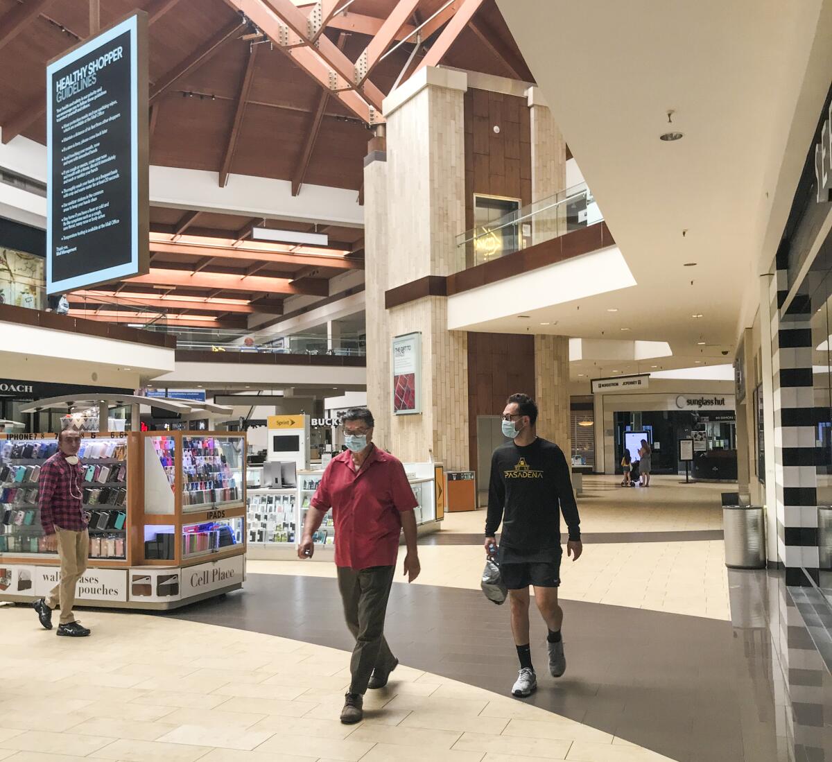 Shoppers walk around Orange County's Brea Mall, which reopened Tuesday. 