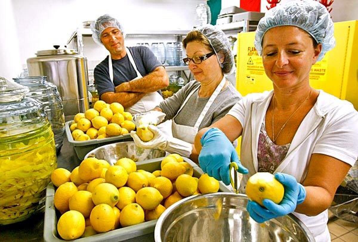 Rossana Zaretti, center, and daughter Manuela Zaretti-Carling, with Manuela's husband, Ventura Limoncello co-owner James Carling, peel lemons for limoncello.