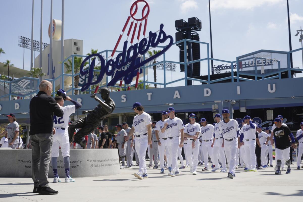 Players and coaches from the Dodgers and Washington Nationals take part in a tribute to Jackie Robinson.
