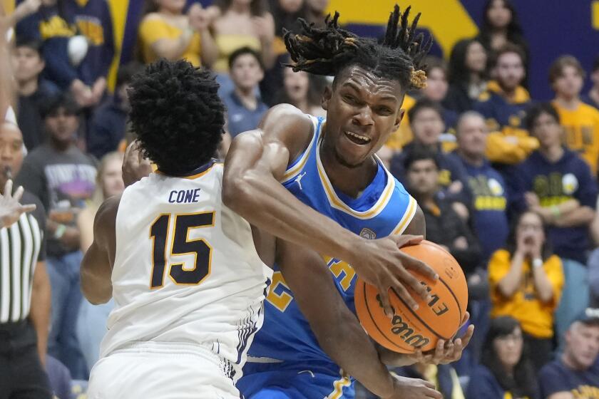 UCLA guard Dylan Andrews, right, is fouled by California guard Jalen Cone.