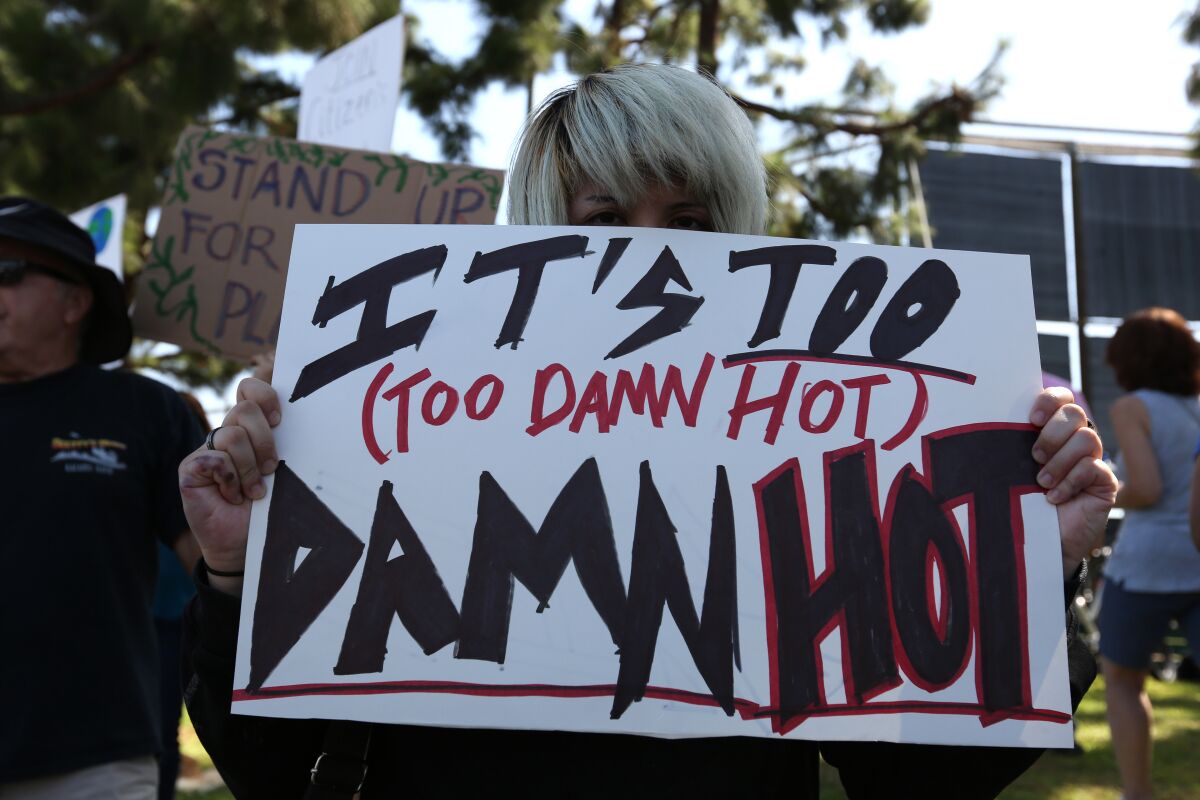 Sage Boleyn, 24 of Irvine, holds a protest sign during a “Climate Strike” climate change protest in Irvine in 2019.