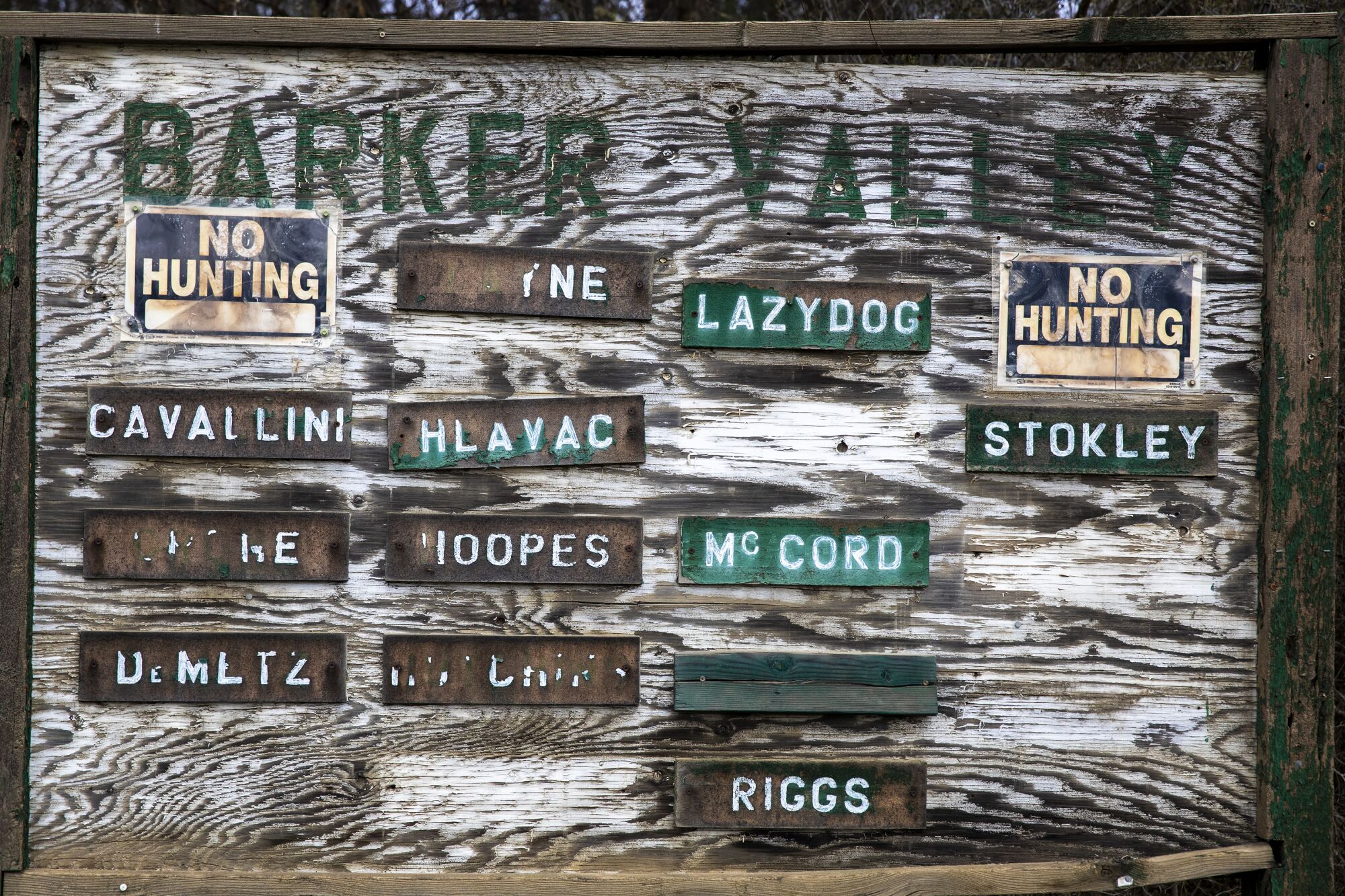 Family names and no hunting signs on a Hayfork community board