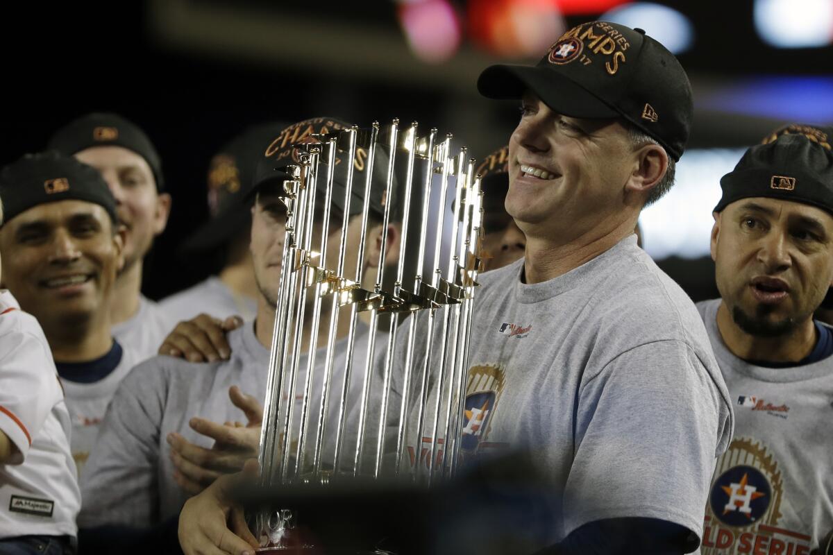 Then-Houston manager A.J. Hinch holds the championship trophy after the Astros beat the Dodgers 5-1 in Game 7 of the World Series on Nov. 1, 2017.