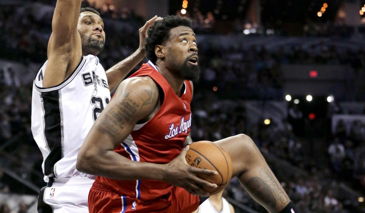 Clippers center DeAndre Jordan pulls down an offensive rebound in front of Spurs forward Tim Duncan in the first half of Game 3.