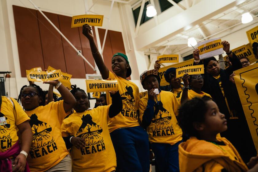 Students and families from Oakland voice their support of the Oakland Reach agenda during the Oakland Unified School Board meeting at the La Escuelita Elementary School in Oakland, Calif. Wednesday, Dec. 12, 2018. (Mason Trinca for The Los Angeles Times)