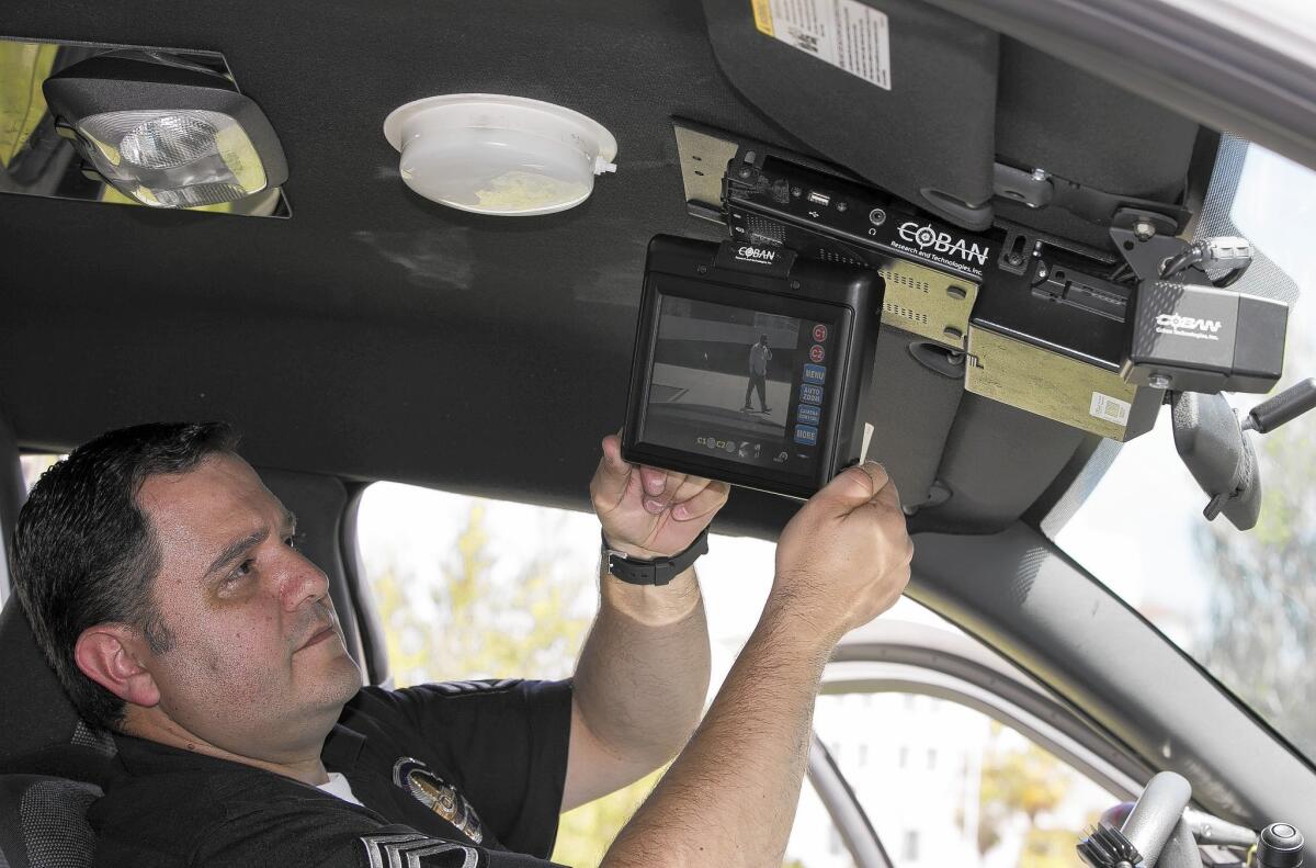 Los Angeles Police Sgt. Dan Gomez, a department expert on recording devices, shows a video display inside a patrol car with a camera pointed through the windshield.