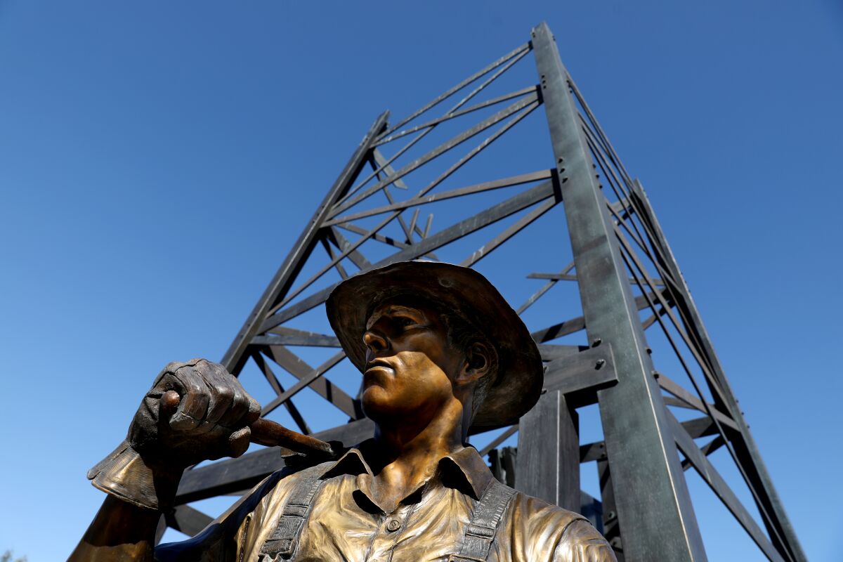 A bronze statue of an oil worker