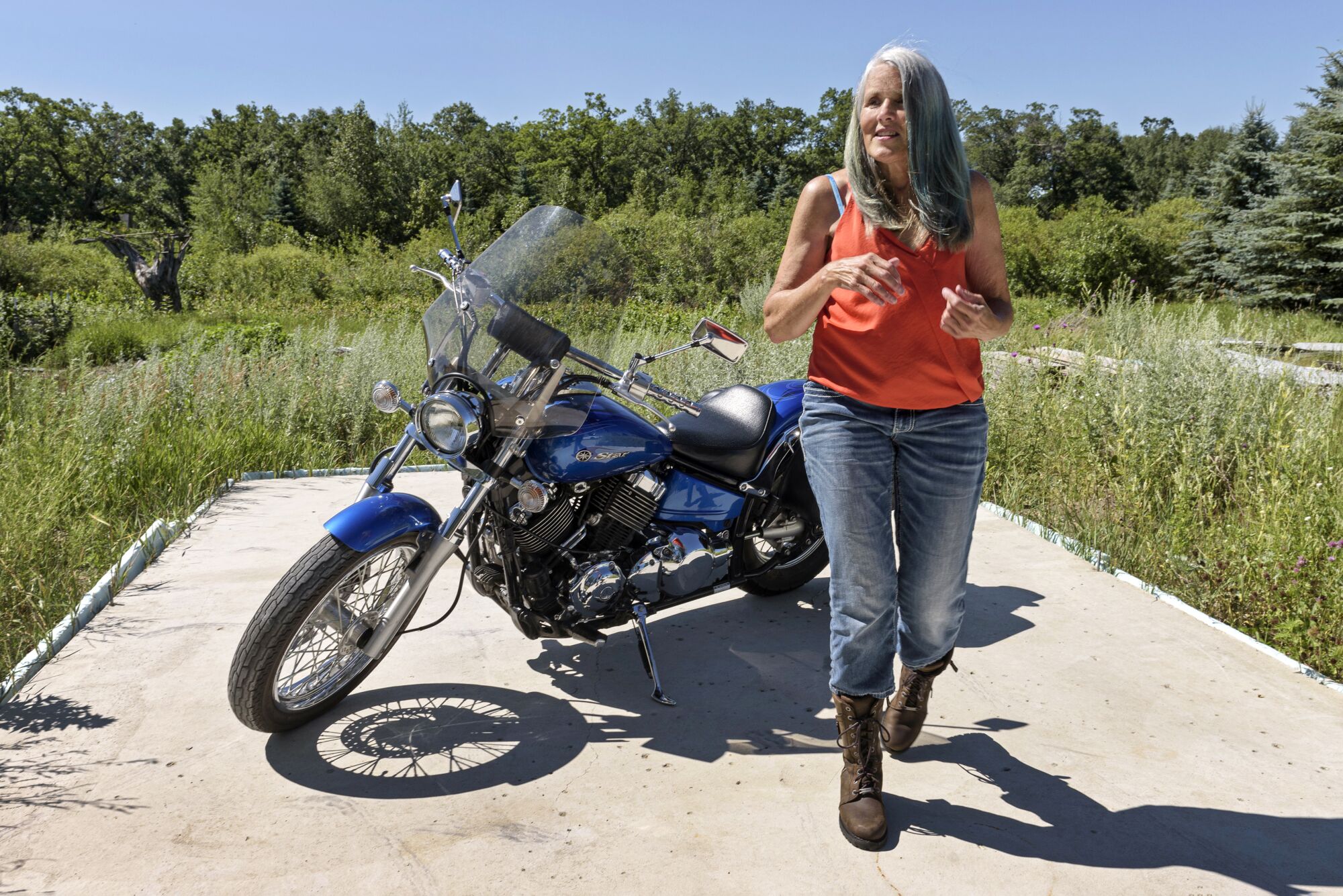 Marcy Ugstad parks her motorcycle outside the Ugstads' lakeside home.