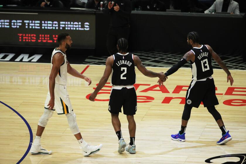 Clippers Kawhi Leonard, left, and Paul George congratulate each other in front of Utah center Rudy Gobert