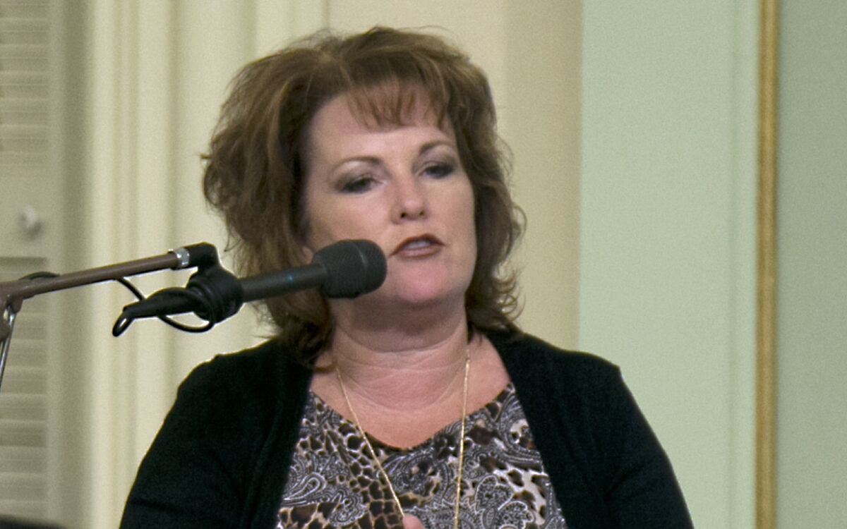 A woman speaks into a microphone 