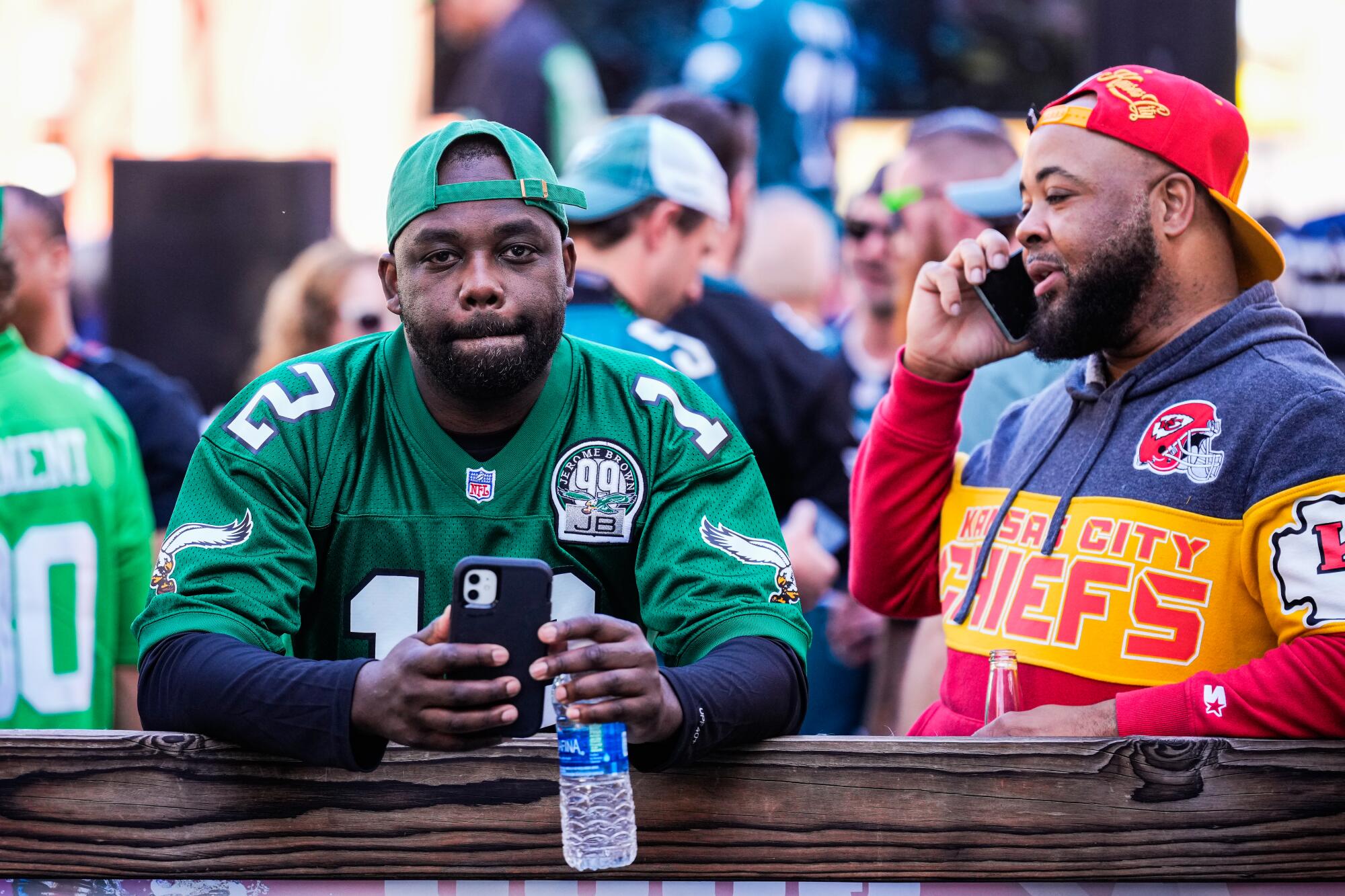 An Eagles fan stands beside a Chiefs fan during a Super Bowl tailgate party in Glendale, Arizona