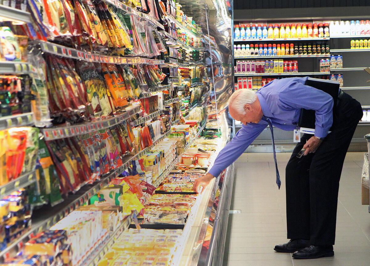 Jim Veregge, of Unified Grocers, checks shelves in a refrigerated section to make sure products his company provides are well presented and fully stocked at Gelson's in La Cañada Flintridge on Monday, March 24, 2014. The store had its grand opening on March 27 at 9:00 A.M.