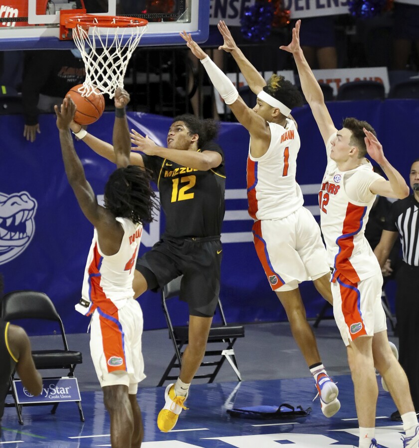 Missouri guard Dru Smith (12) goes up and under the basket to score the game winning basket against Florida during an NCAA college basketball game, Wednesday, March 3, 2021 in Gainesville, Fla. (Brad McClenny/The Gainesville Sun via AP)