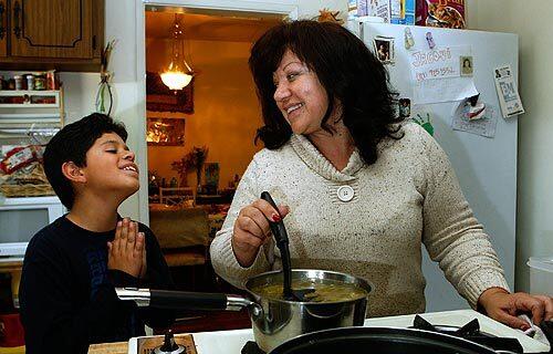 Alicia Cardenas fixes dinner as son Anthony, 9, pleads for a snack at their North Hollywood home. With help from a financial planner, Cardenas staved off foreclosure by renegotiating her high-interest adjustable-rate mortgage into a more manageable fixed-rate mortgage.