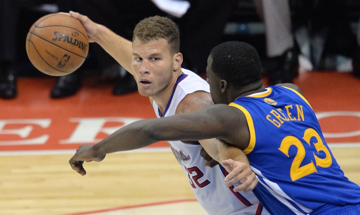 Clippers power forward Blake Griffin, left, keeps the ball away from Golden State Warriors forward Draymond Green during the Clippers' blowout victory in Game 2 of the NBA Western Conference quarterfinals Monday.