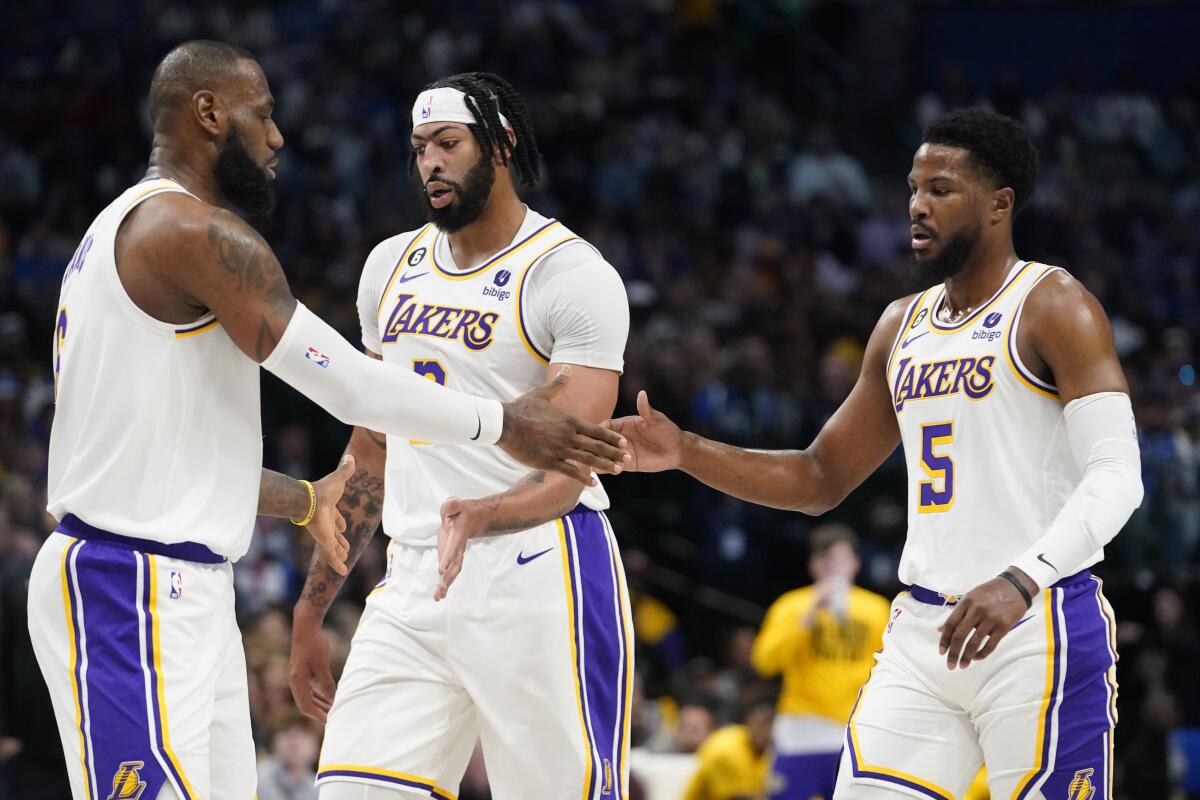 Lakers teammates (from left) LeBron James, Anthony Davis and Malik Beasley congratulate one another.