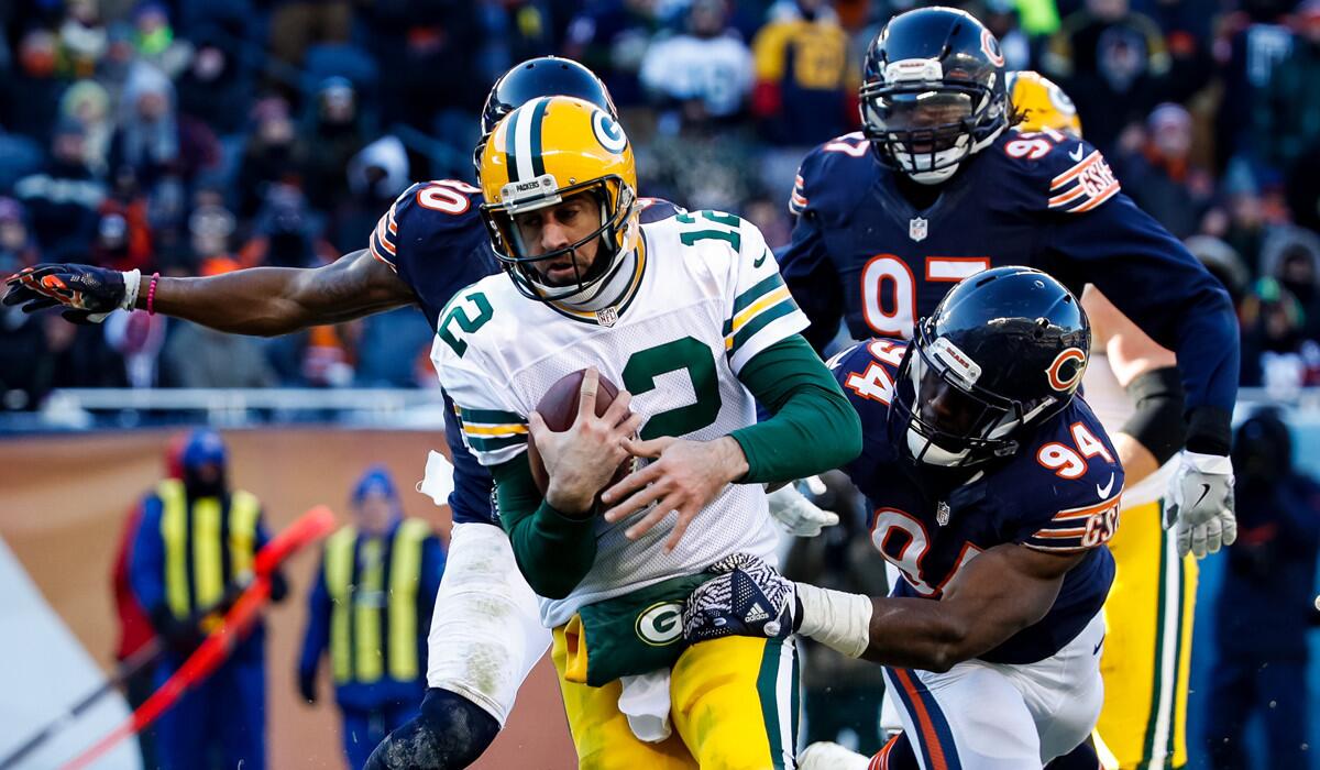 Chicago Bears' Leonard Floyd (94) grabs onto Green Bay Packers quarterback Aaron Rodgers (12) in the third quarter on Sunday.