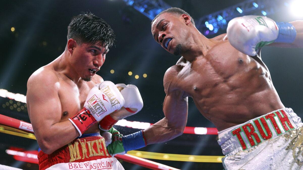 Mikey Garcia, left, takes a blow to the body from Errol Spence Jr. during the ninth round of the IBF welterweight championship bout on March 16, 2019, in Arlington, Texas.