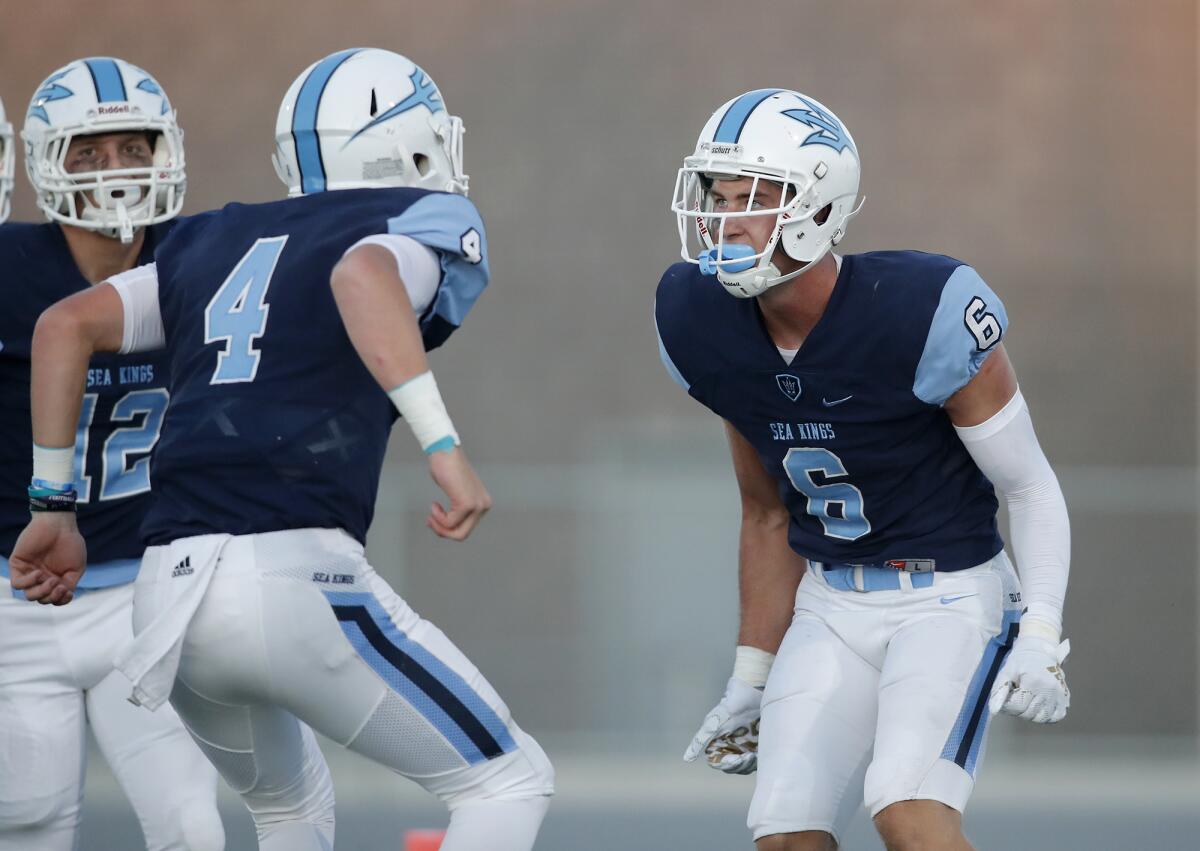 Corona del Mar quarterback Ethan Garbers (4) celebrates with receiver John Humphreys (6) after throwing one of two first-half touchdowns to Humphreys in a season opener against Downey at Newport Harbor High on Aug. 23, 2019.