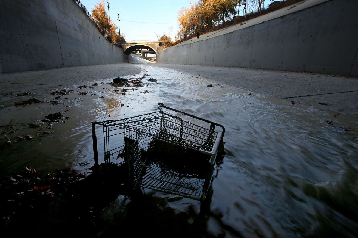 A grocery cart lies in the stream of the Arroyo Seco at its confluence with the Los Angeles River north of downtown. Plans to revitalize the long neglected L.A. River corridor includes $6 billion in real estate investment.