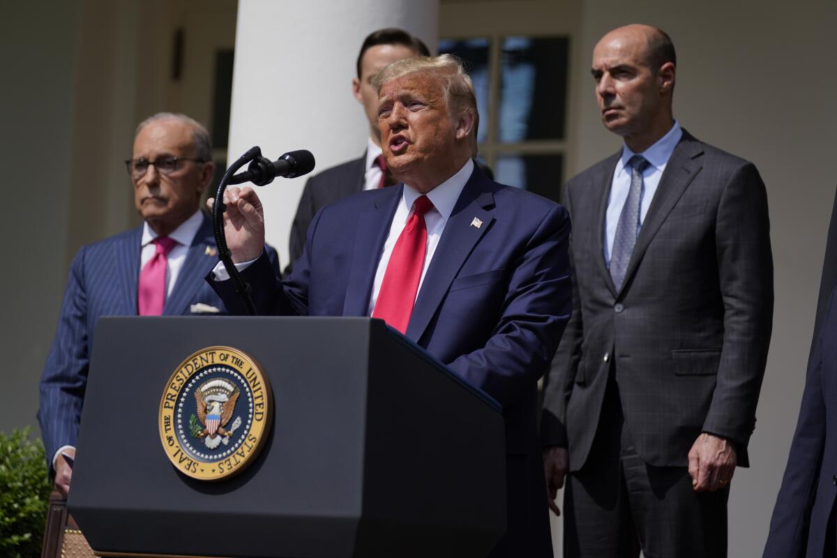 Then-President Trump speaks at a lectern outside the White House.