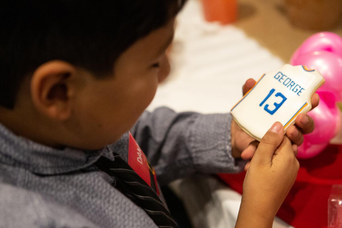 Daniel Hernandez, 10, enjoys a cookie from Clippers star Paul George.