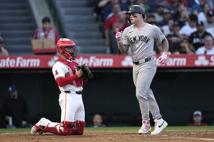 New York Yankees' Alex Verdugo, right, gestures as he scores on a solo home run, next to Los Angeles Angels catcher Logan O'Hoppe during the fourth inning of a baseball game Wednesday, May 29, 2024, in Anaheim, Calif. (AP Photo/Mark J. Terrill)