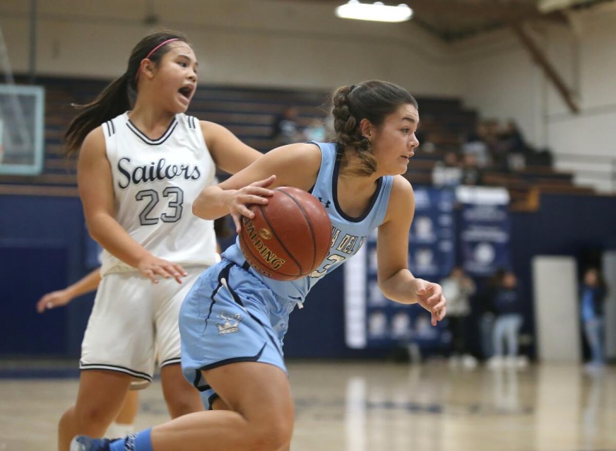 Corona del Mar’s Trasara Alexander drives around Newport Harbor’s Cydney Jover during the Battle of the Bay game on Jan. 9.