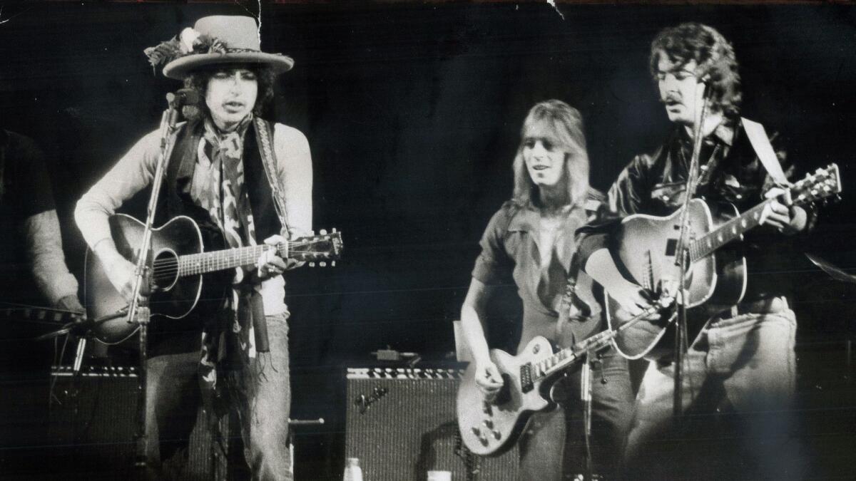 Bob Dylan, left, Mick Ronson and Bobby Neuwirth perform in Dylan's Rolling Thunder Revue tour in 1975.
