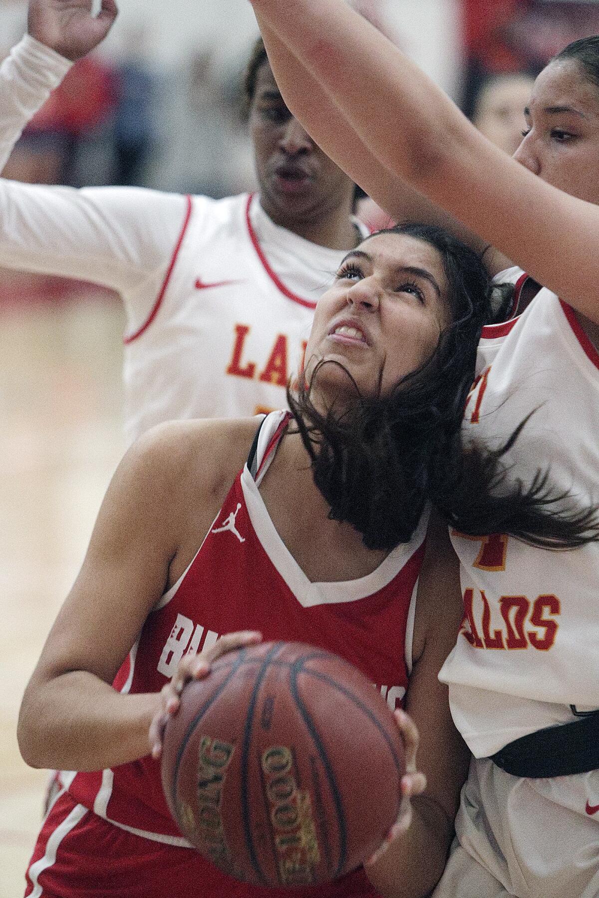 Burroughs' Noor Fahs pulls down an offensive rebound and is fouled by Whittier Christian's Aidan Sherfey in the CIF Southern Section Division II-A girls' basketball quarterfinal at Whittier Christian High School in La Habra on Wednesday, February 19, 2020. Burroughs won the game 41-39, a game that was hard fought until the last points were scored
